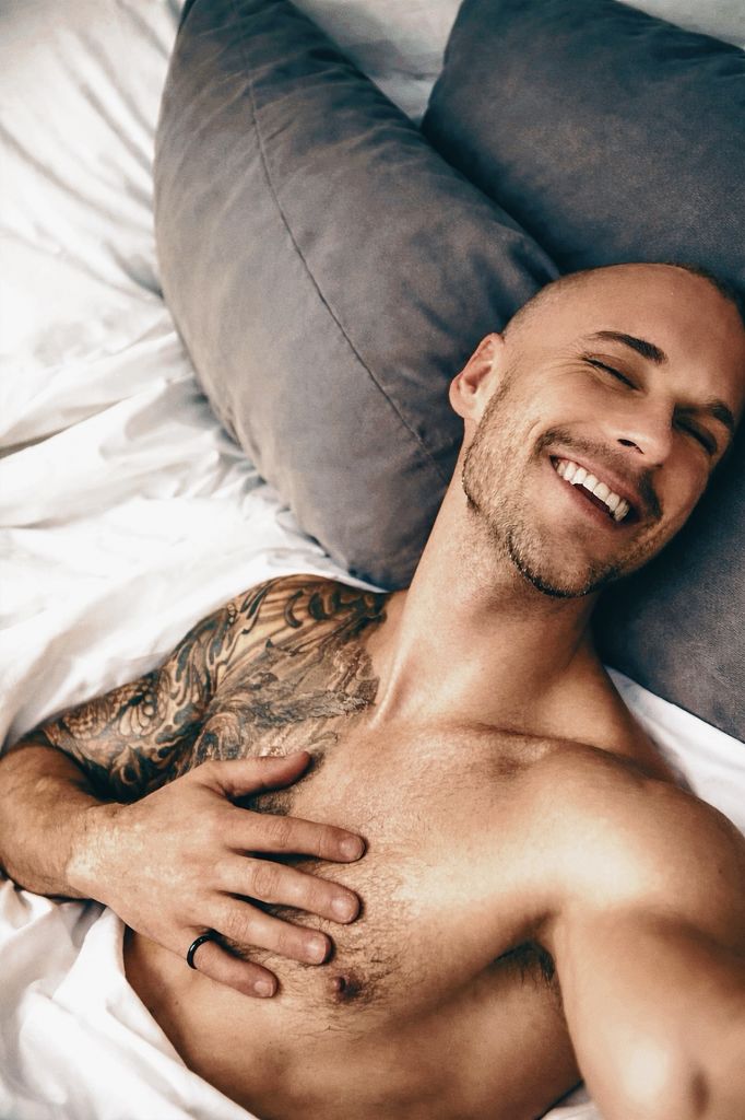 Niko Santano laughing on white linens